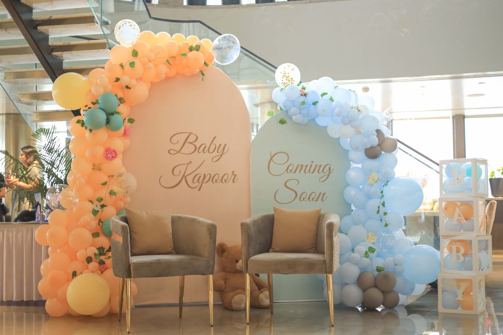 Decorated baby shower setup with a balloon arch and seating