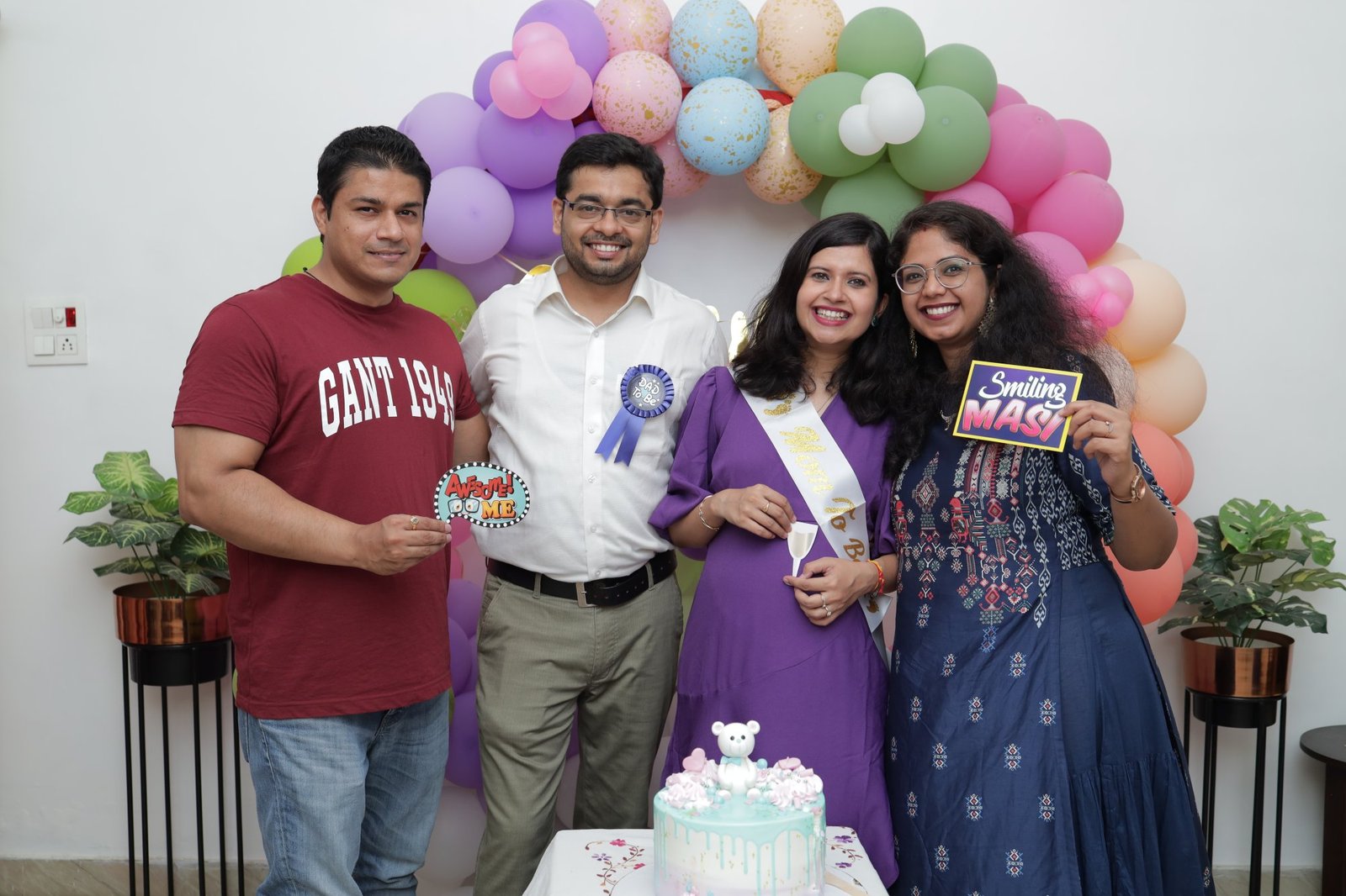 Family photographed together at a pastel balloon arch
