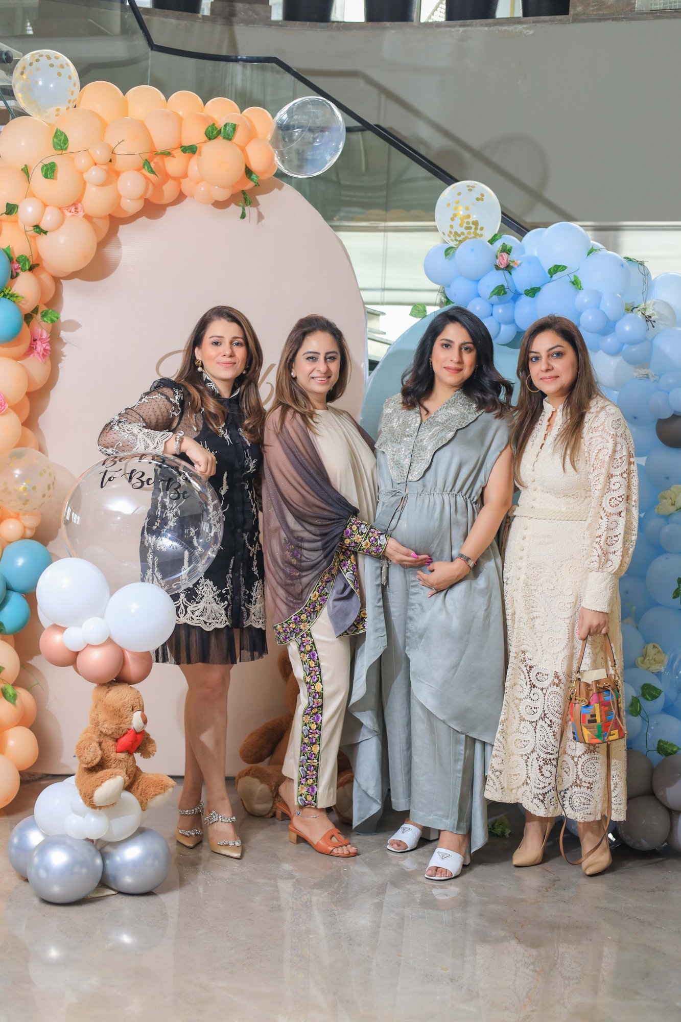 Guests photographed together in front of a pastel balloon arch