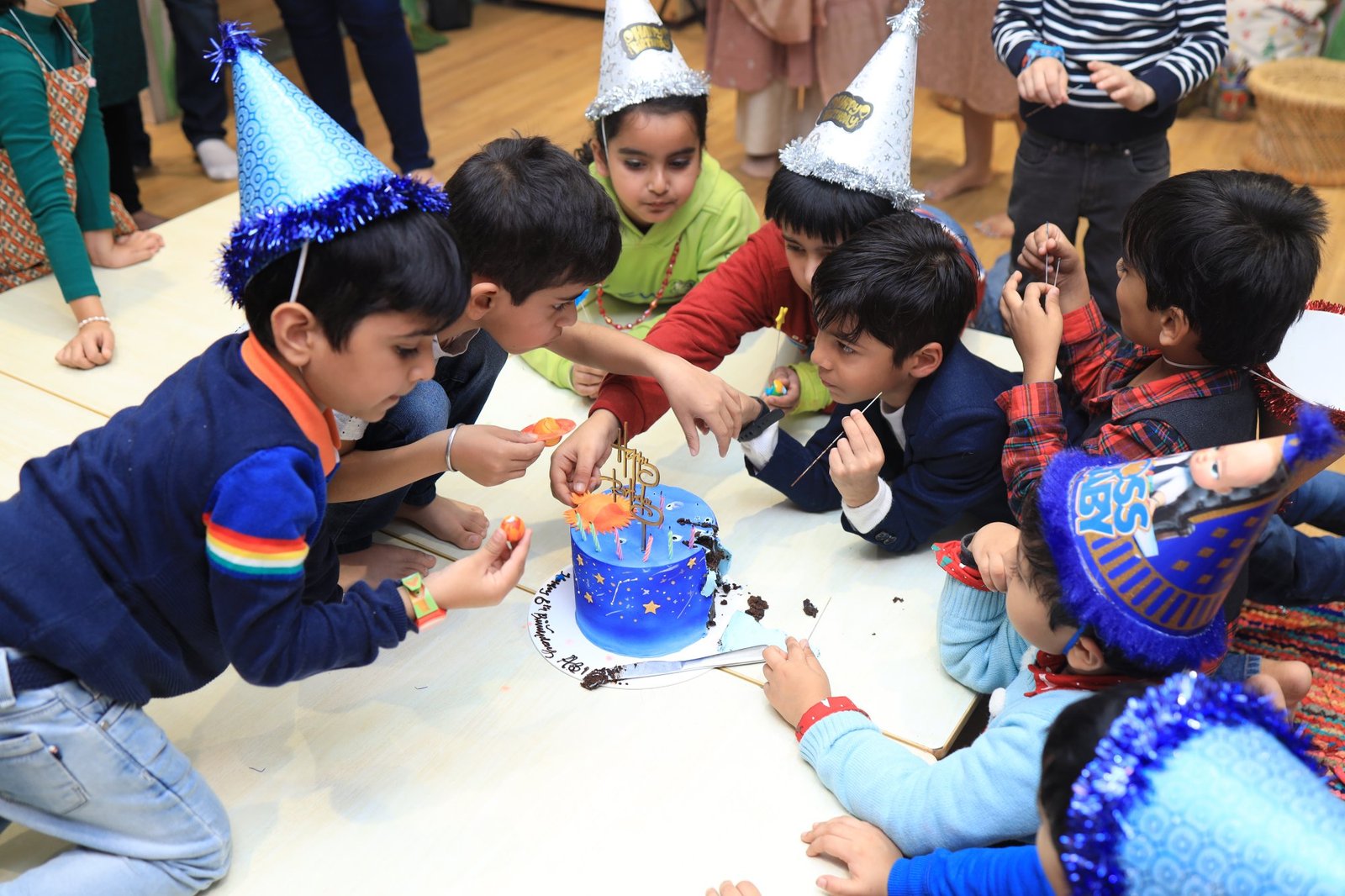 Children crowding around the birthday cake