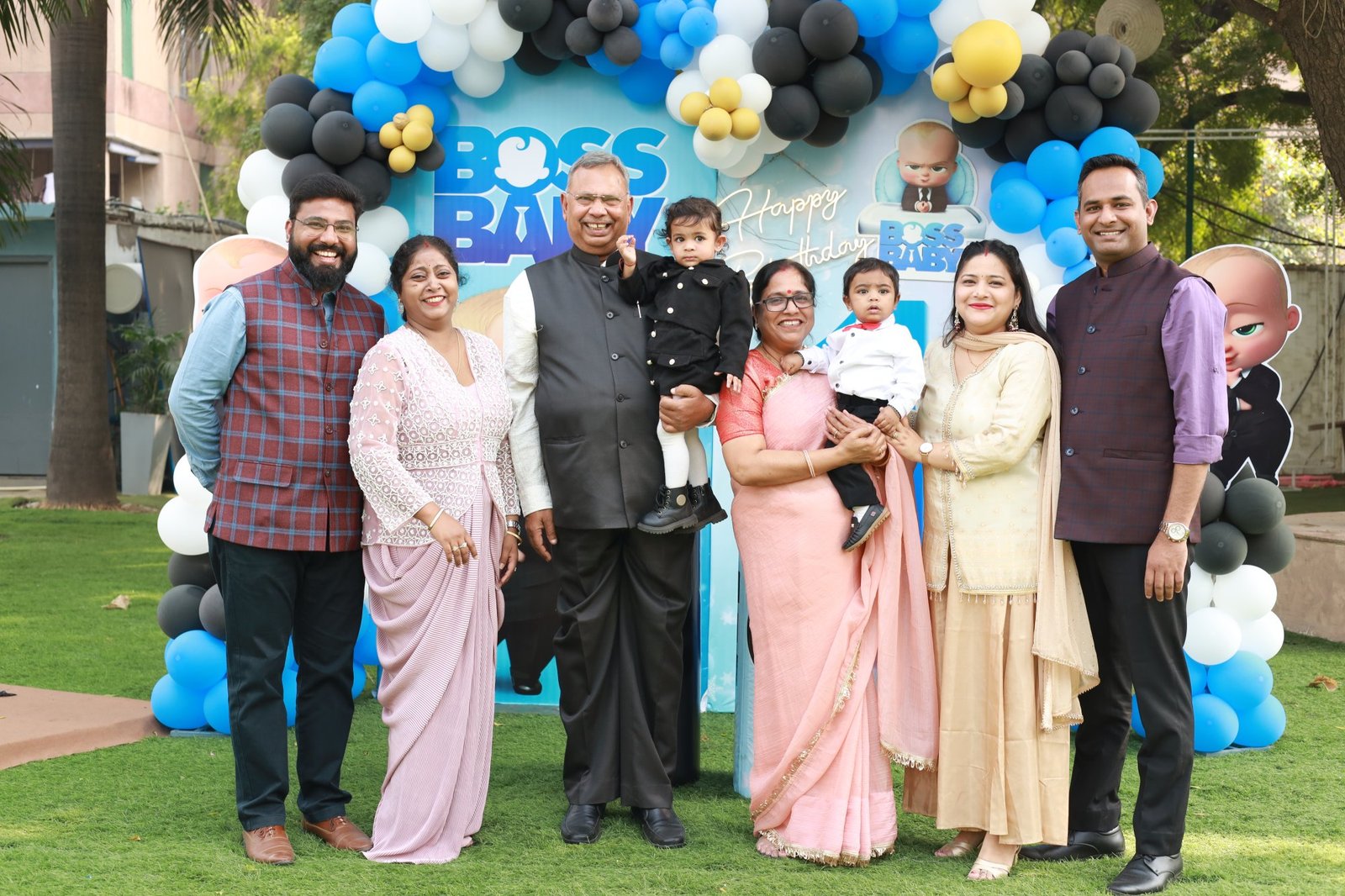 Extended family gathered in front of the party backdrop