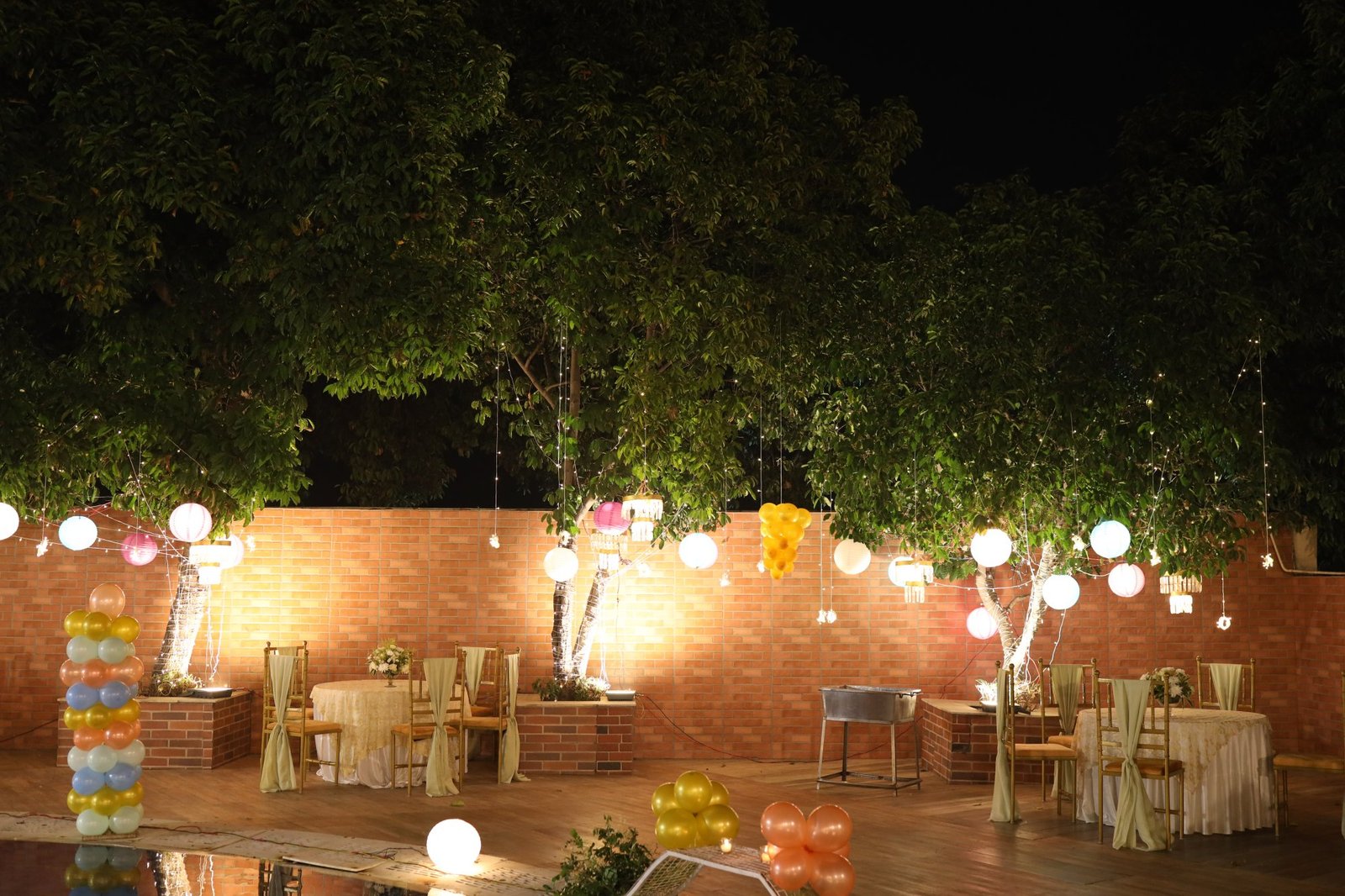 Garden venue set with tables and warm lighting for an evening party