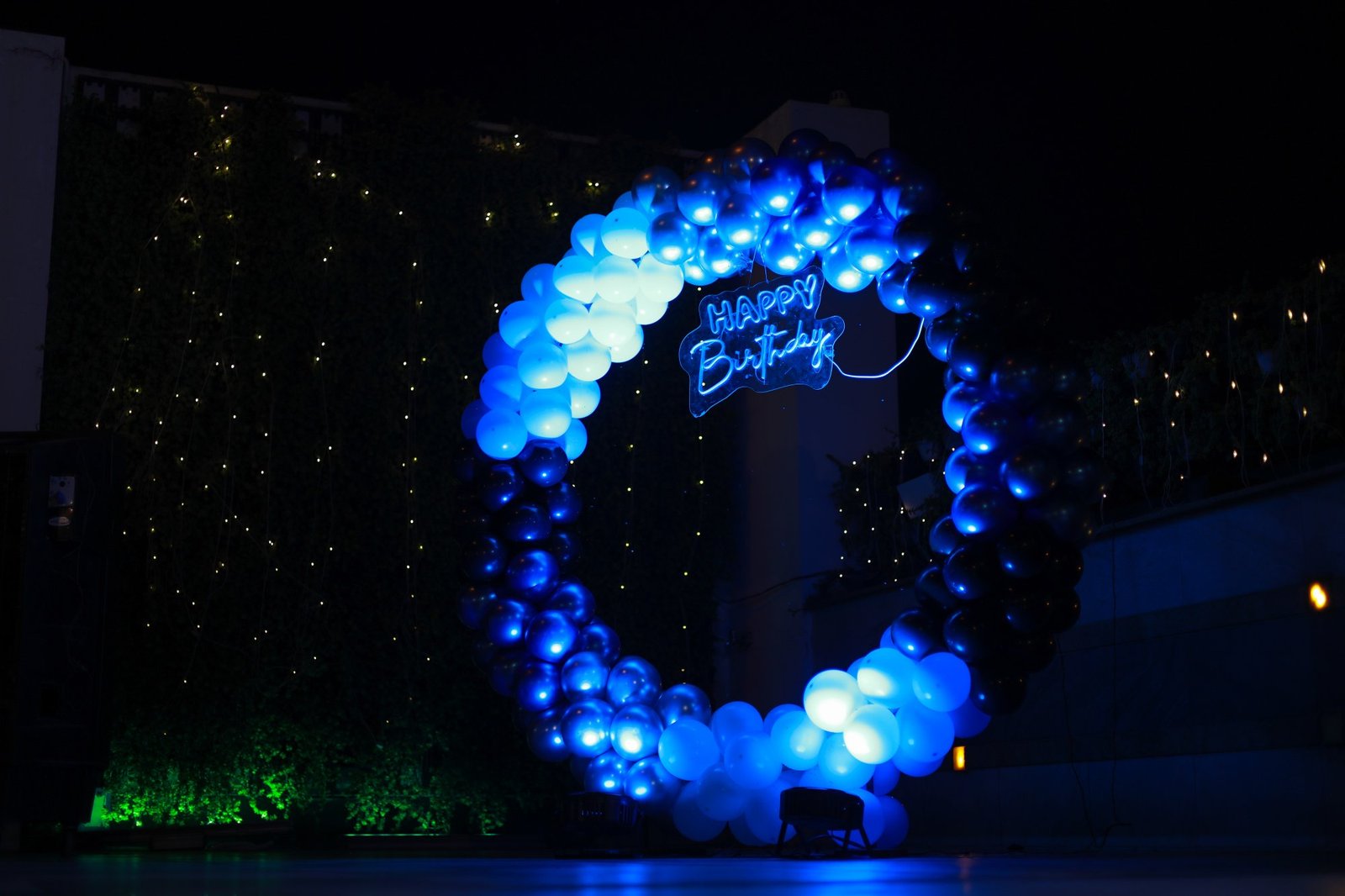 Illuminated blue balloon decoration at an evening birthday celebration