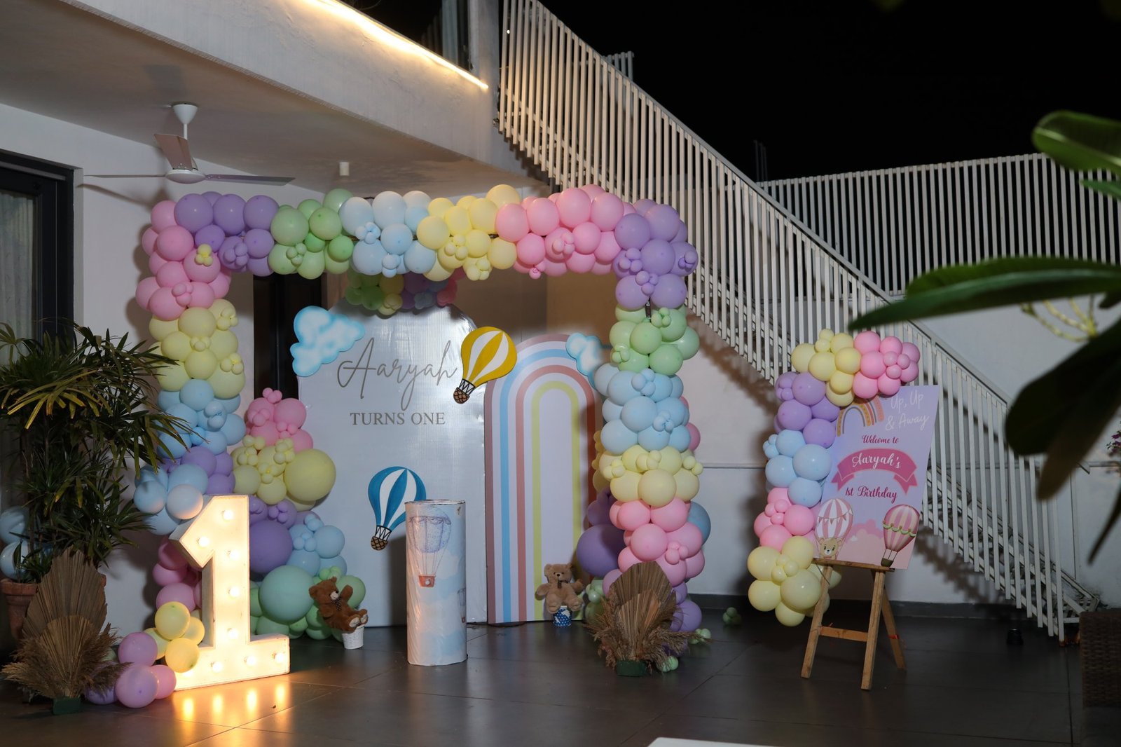 Pastel balloon arch and styled backdrop at a first birthday venue