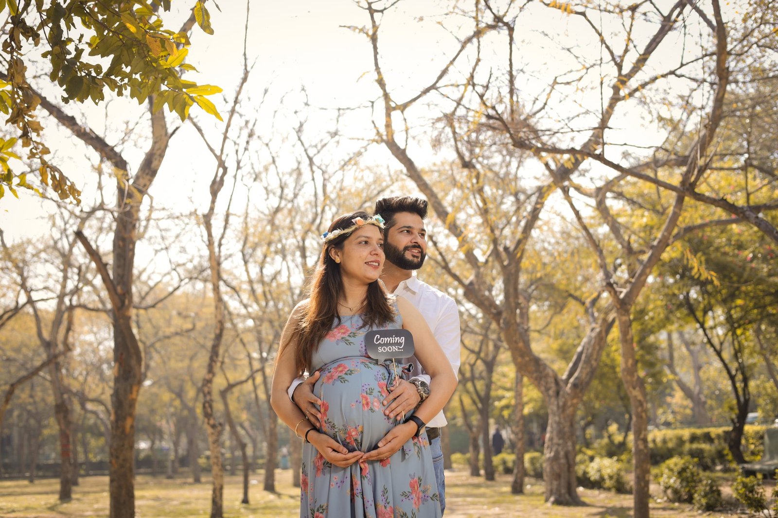 Expectant couple photographed among bare winter trees