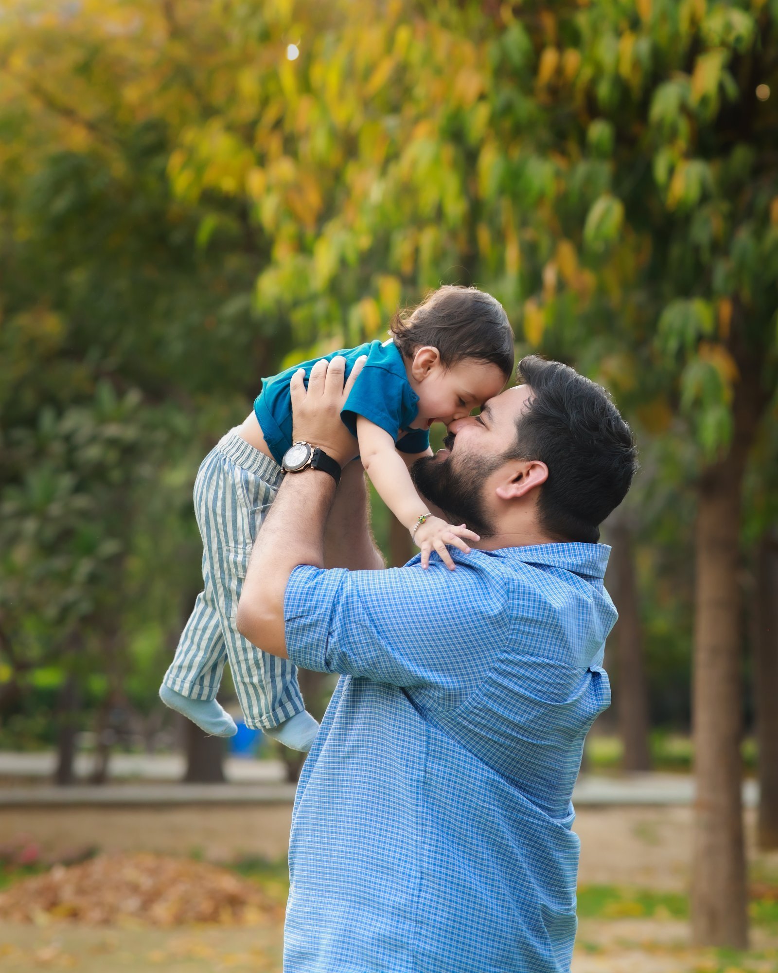 Father lifting his baby into the air during an outdoor session